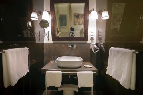 a bathroom with a sink and a mirror and towels at 4Rooms 4U in Belgrade