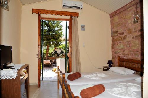 1 Schlafzimmer mit 2 Betten und einer Tür zu einer Terrasse in der Unterkunft Topakas House in Kambos