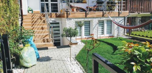 a house with a garden with a hammock in the yard at Gaia Studio in Wrocław