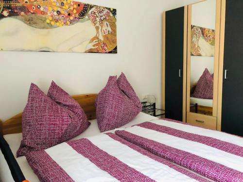 a purple and white bed with purple pillows on it at Ferienhaus Villach in Villach