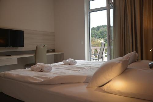 um quarto de hotel com uma cama com toalhas em Hotel Fiesa em Piran