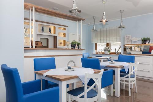 a dining room with two tables and blue chairs at VivaLaMer in Pobierowo