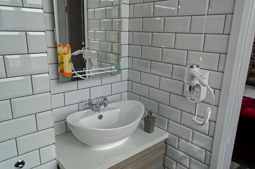 a white bathroom with a sink and a mirror at Potbank in Stoke on Trent