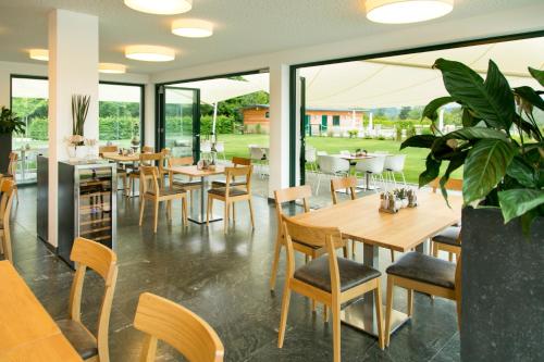 a restaurant with tables and chairs and windows at Fishery Steffan in Sankt Kanzian