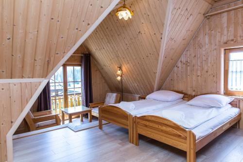 Łóżko w pokoju z drewnianym sufitem w obiekcie udanypobyt Apartament Przy Lesie w mieście Kościelisko