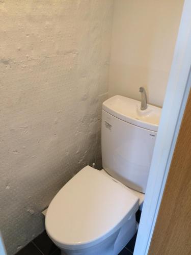 a bathroom with a white toilet and a sink at ROUTE - Cafe and Petit Hostel in Nagasaki