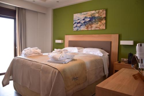 ein Schlafzimmer mit einem Bett, auf dem Handtücher liegen in der Unterkunft Plytra Mare Hotel in Plitra