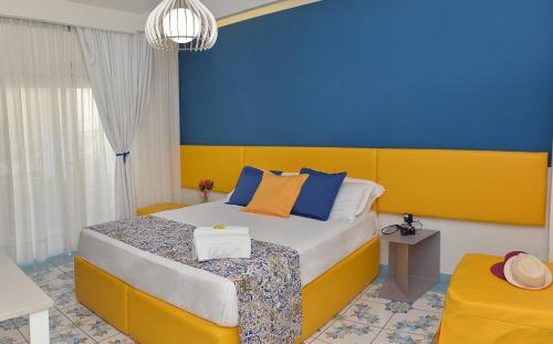 1 dormitorio con 1 cama con pared azul y amarilla en San Domenico Accommodation Maiori, en Maiori