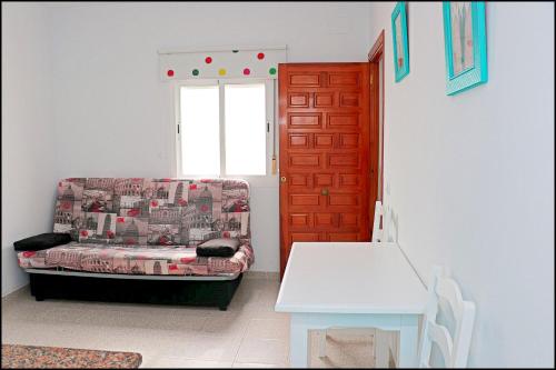 コニル・デ・ラ・フロンテーラにあるApartamento cerca de la playaのソファ、テーブル、窓が備わる客室です。