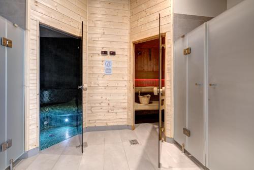 een badkamer met een douche en een zwembad bij Live & Travel Apartments - Waterlane Island in Gdańsk