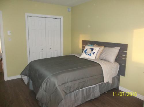 a bedroom with a bed and a white door at Cottage Jasmine on the Shediac Bay with hot tub in Shediac