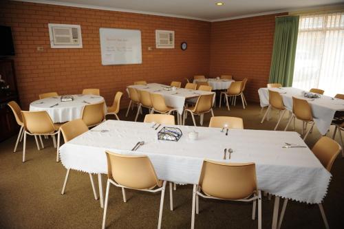 a room with tables and chairs with white tablecloths at Mildura Plaza Motor Inn in Mildura