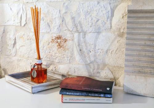 a vase sitting on top of books on a table at BiancoAmore OSTUNI - the sky, the sea, the love - in Ostuni