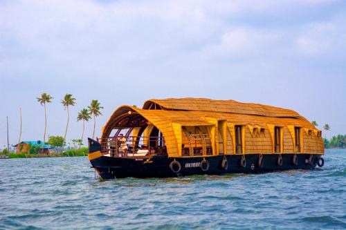 a boat with a bamboo roof on the water at Marvel Cruise in Alleppey