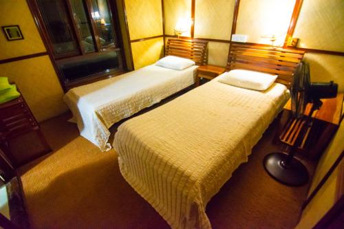 a hotel room with two beds and a window at Marvel Cruise in Alleppey