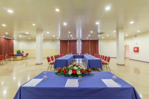 a meeting room with blue tables and red chairs at Hotel Eurosol Alcanena in Alcanena