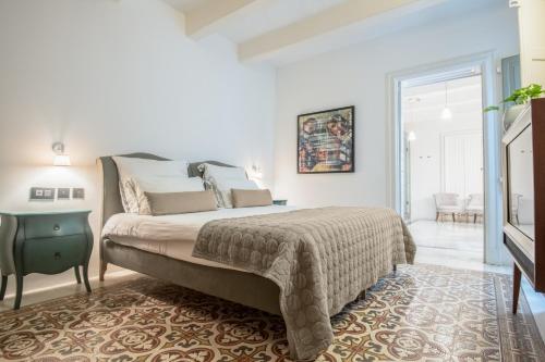 a bedroom with a bed and a table and a window at Casa Ellul - Small Luxury Hotels of the World in Valletta