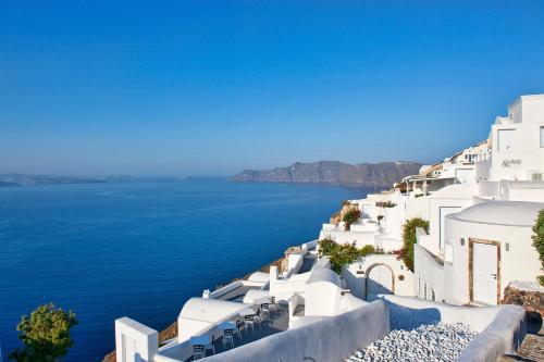 a view of the ocean from the side of a white building at Canaves Ena - Small Luxury Hotels of the World in Oia
