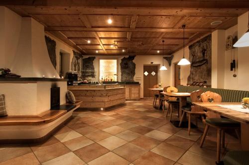 a large kitchen with wooden ceilings and tables and chairs at Herol - my mountain retreat in Luson