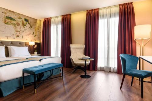 een hotelkamer met een bed, een bureau en stoelen bij Áurea Museum by Eurostars Hotel Company in Lissabon