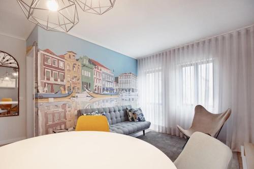 a room with a couch and chairs and a painting on the wall at Canal Apartment in Aveiro