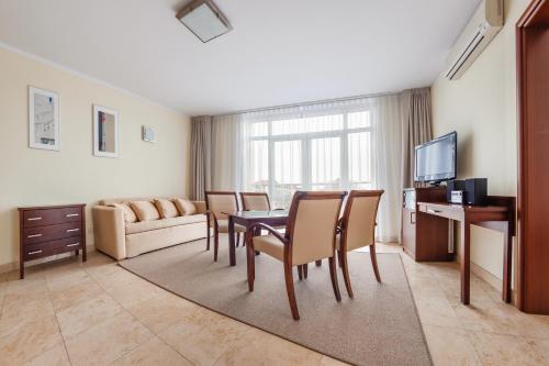 sala de estar con mesa, sillas y sofá en Apartamenty Sun & Snow Avenue, en Świnoujście