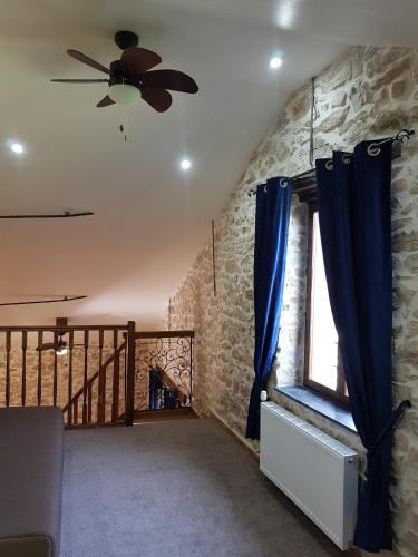 a living room with a ceiling fan and a window at Domaine de Vareilles in Vareilles