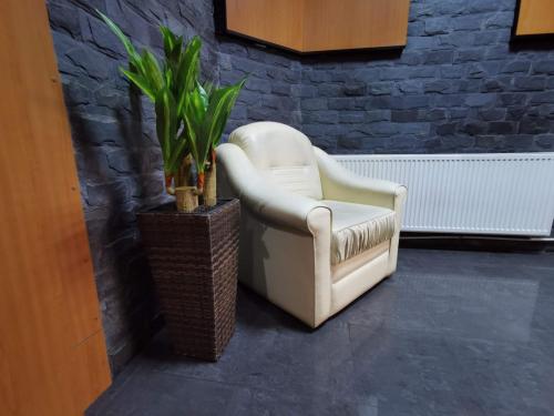 a white chair sitting next to a brick wall at Pensiunea Stefan in Bistriţa