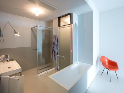 a bathroom with a shower and a red chair at Antonello Colonna Resort & Spa in Labico