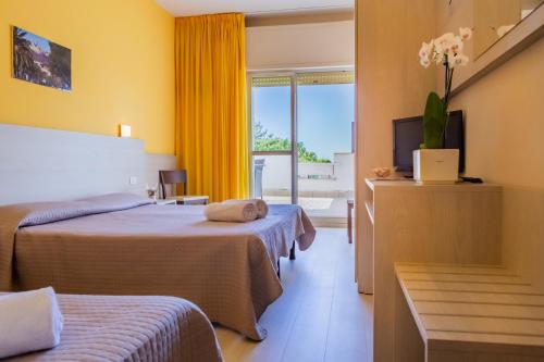 a hotel room with two beds and a window at Hotel Holiday in Vasto
