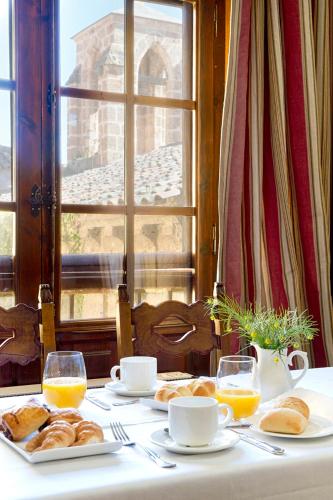 a table with plates of bread and glasses of orange juice at Monasterio De Piedra in Nuévalos