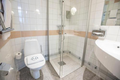 a bathroom with a toilet and a shower and a sink at The Vault Hotel, WorldHotels Crafted in Helsingborg