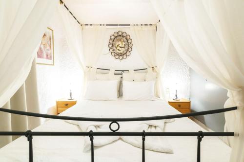 1 dormitorio con cama con dosel y cortinas blancas en Contessina House, en Zakynthos