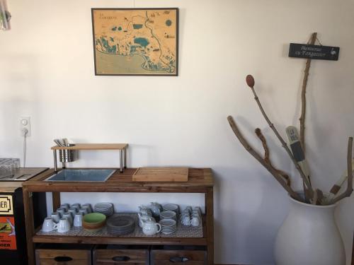 a table with dishes on it next to a vase at Le Fangassier in Saintes-Maries-de-la-Mer
