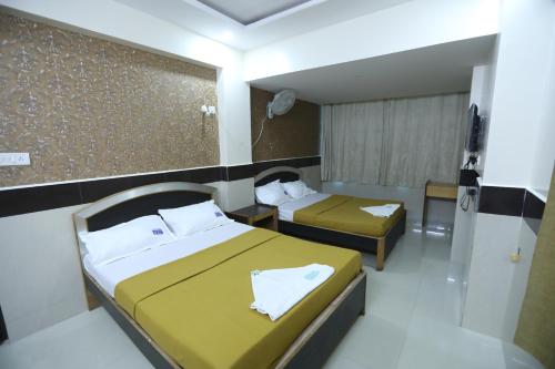 um quarto de hotel com duas camas e uma janela em Hotel Embassy em Bangalore