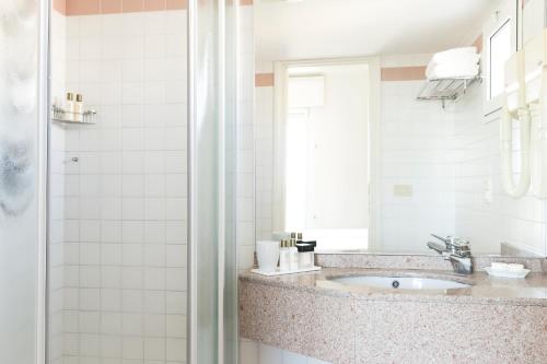 a bathroom with a sink and a shower at Hotel Cambridge in Lido di Jesolo