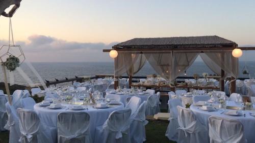 a wedding reception with white tables and white chairs at Toxotis Villas in Armenistis