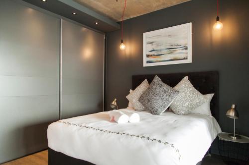 a bedroom with a large white bed with pillows at Wex 1 Apartments in Cape Town
