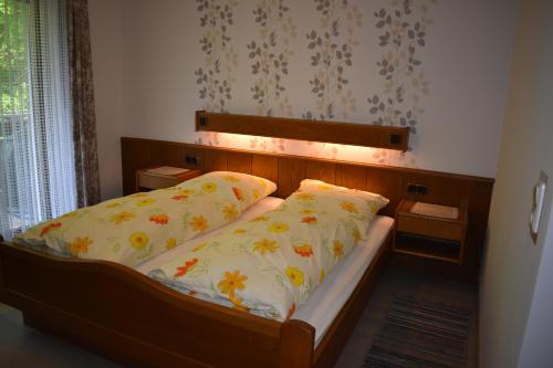 uma cama com cabeceira e duas almofadas em Pension Haus am Waldesrand em Schieder-Schwalenberg