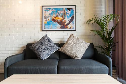 a couch with two pillows on it in a room at Wex 1 Apartments in Cape Town