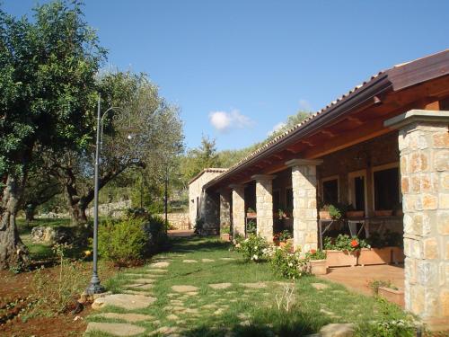 a stone building with a yard with a tree at Hotel Relais Pian delle Starze in Marina di Camerota
