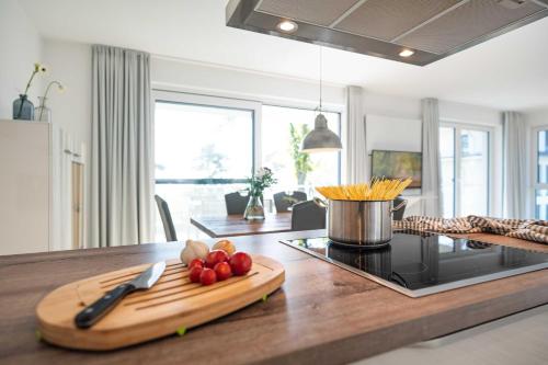 Una cocina con una tabla de cortar con verduras en una mesa. en Appartement Haffperle-Oase am Haff, en Garz