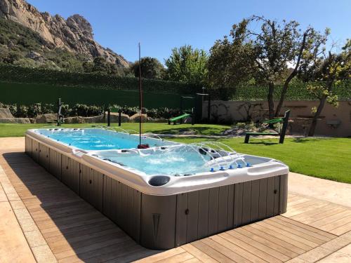 a hot tub in the middle of a yard at Antica Fonte Holiday Homes in San Pantaleo