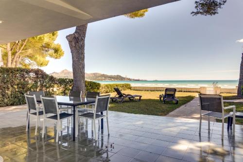 アルクーディアにあるVilla Garballo Alcudia - Sea Frontのビーチを背景にテーブルと椅子