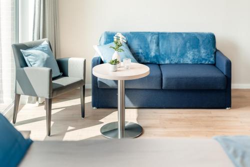 a living room with a blue couch and a table at Gasthaus Großenmeer in Ovelgönne