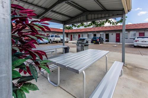 a group of benches sitting in a parking lot at Best Western Endeavour Motel in Maitland