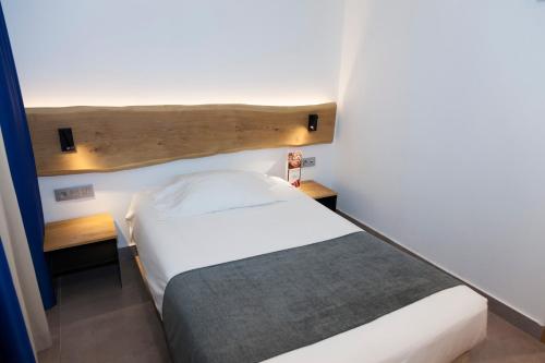 a small bedroom with a white bed and wooden headboard at Hostal Paris in Barcelona