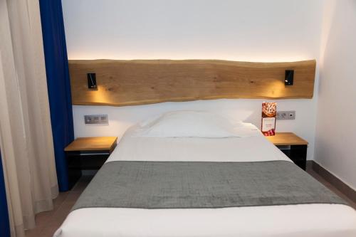 a bedroom with a white bed with two wooden tables at Hostal Paris in Barcelona