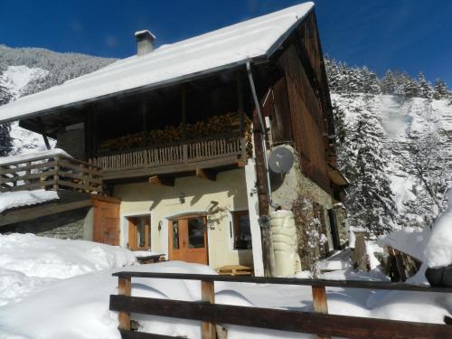 ein Blockhaus mit Balkon im Schnee in der Unterkunft L'Epicéa in Saint-Jean-dʼArves