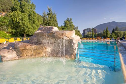 a swimming pool with a waterfall in a park at Apartaments Giberga in LʼAldosa